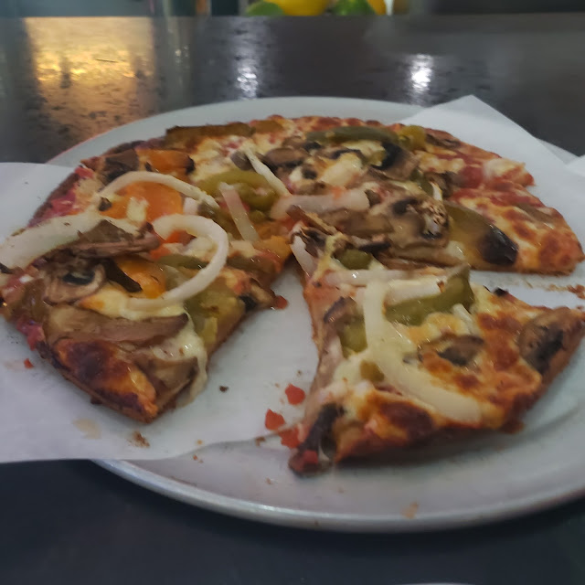 Cauliflower Crusted Pizza with Onions Peppers & Mushrooms