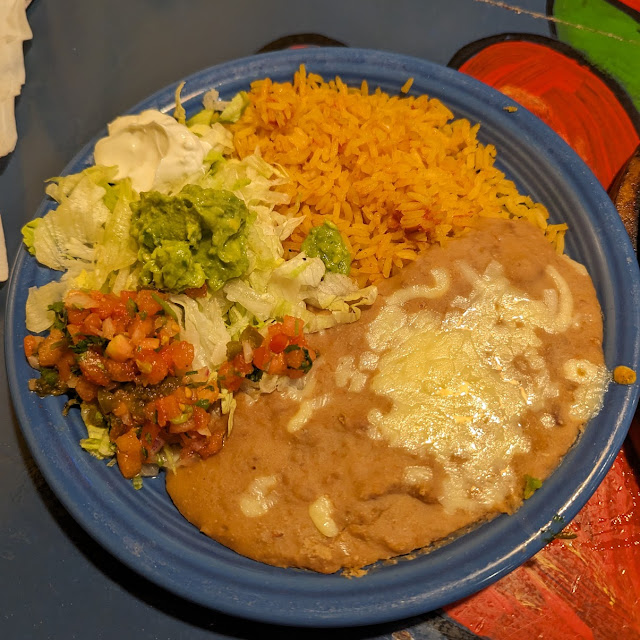 Side Dish of Refried Beans Guacamole Lettuce and Salsa